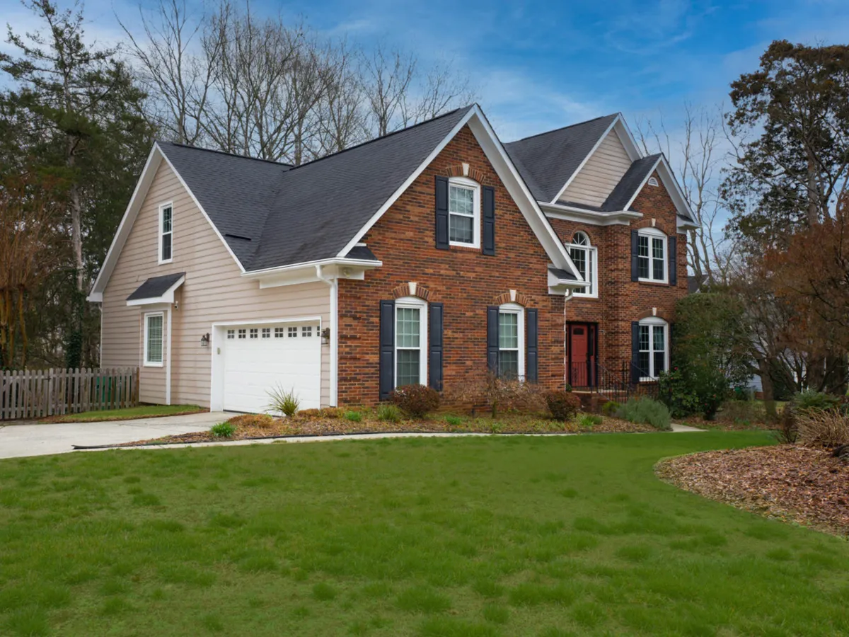 This image showcases the brick facade of a house with large windows, a welcoming front door, and a neatly manicured lawn. The landscaping and inviting entryway highlight the property’s quiet, professional neighborhood setting—ideal for business travelers seeking tranquility and a safe environment.