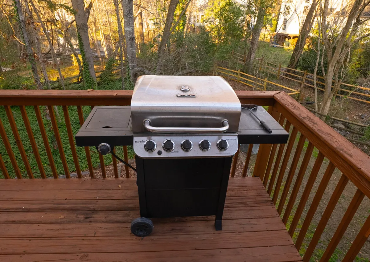 A well-appointed outdoor deck with a grill and comfortable seating area offers a space for relaxing or informal meetings. Surrounded by greenery, it provides an opportunity to unwind or connect after a busy workday.